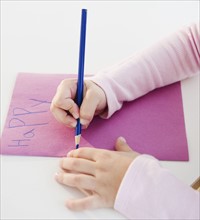 Child writing a birthday card. Photographe : Jamie Grill