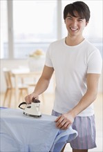 Man ironing his shirt. Photographe : Daniel Grill