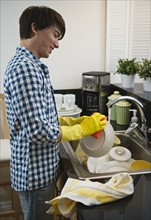 Man washing dishes. Photographe : Daniel Grill