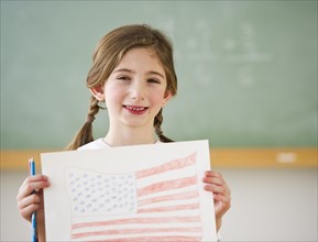 Child holding drawing of American flag. Photographe : Daniel Grill