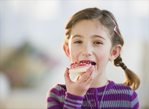 Young girl eating a cookie. Photographe : Daniel Grill