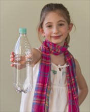 Young girl holding a plastic water bottle. Photographe : Daniel Grill