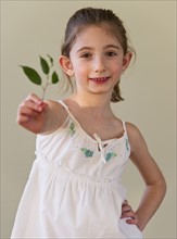 Young girl holding green leaves. Photographe : Daniel Grill