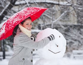 Woman making a snowman. Photographe : Daniel Grill