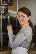 Woman preparing coffee in coffee shop. Photographe : Daniel Grill