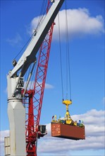 Crane lifting shipping container. Photographe : fotog