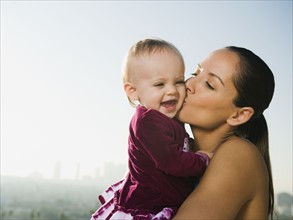 Woman kissing toddler.
