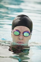 Woman wearing bathing cap and swimming goggles.