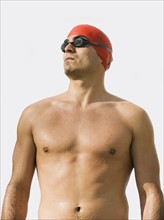 Man wearing bathing cap and swimming goggles.