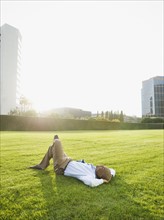 Businessman relaxing on lawn.
