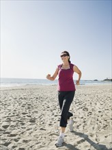 Woman jogging on beach.