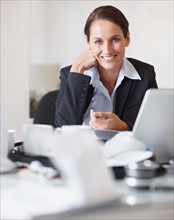 Businesswoman at her desk. Photographe : momentimages