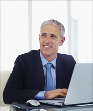 Businessman working on laptop. Photographe : momentimages