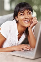 Young woman typing on laptop. Photographe : momentimages