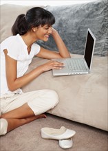 Young woman looking at laptop. Photographe : momentimages