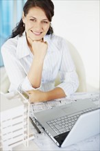 Woman sitting at desk. Photographe : momentimages