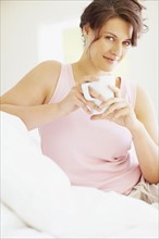 Woman relaxing with a coffee. Photographe : momentimages