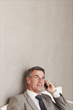 Businessman talking on cellular phone. Photographe : momentimages