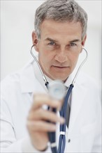 Doctor using stethoscope. Photographe : momentimages