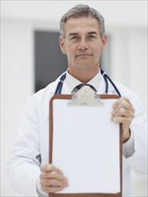 Doctor holding clipboard. Photographe : momentimages