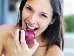 Woman eating an apple. Photographe : momentimages