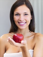 Woman holding an apple. Photographe : momentimages
