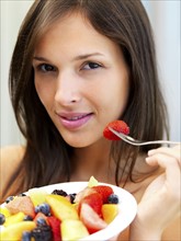 Woman eating fresh fruit. Photographe : momentimages