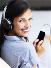 Woman listening to music on headphones. Photographe : momentimages