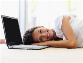 Woman resting beside laptop. Photographe : momentimages