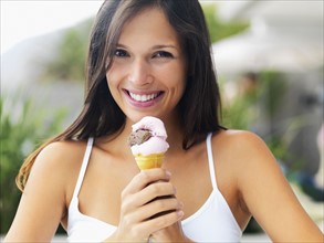 Woman eating ice cream cone. Photographe : momentimages