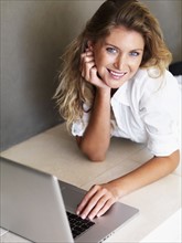 Woman typing on laptop. Photographe : momentimages