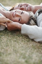 Couple relaxing on the grass. Photographe : momentimages