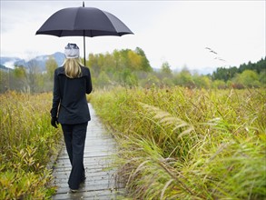 Person walking on boardwalk on rainy day. Photographe : John Kelly