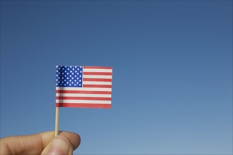 Hand holding small American flag. Photographe : David Engelhardt