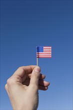 Hand holding small American flag. Photographe : David Engelhardt