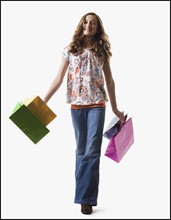 Young girl holding shopping bags. Photographe : Mike Kemp