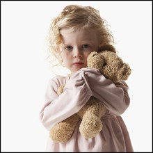 Young girl holding teddy bear. Photographe : Mike Kemp