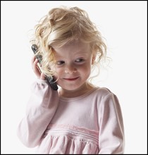 Young girl playing with a cellular phone. Photographe : Mike Kemp