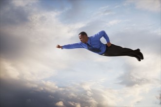 Businessman flying in the sky. Photographe : Mike Kemp