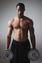 Muscular man lifting dumbbells. Photographe : Mike Kemp