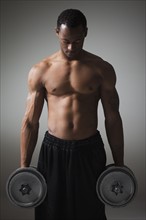 Muscular man lifting dumbbells. Photographe : Mike Kemp