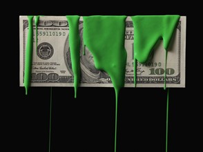 American currency covered in green paint. Photographe : Mike Kemp