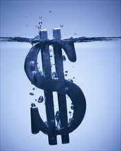 Dollar symbol sinking in water. Photographe : Mike Kemp