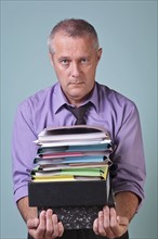 Man holding a stack of paper work. Photographe : RTimages
