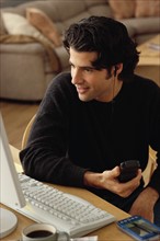 Man looking at home computer. Photographe : Rob Lewine