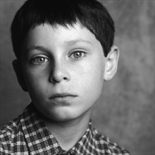 Portrait of a serious young boy. Photographe : Rob Lewine