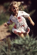 Young girl running outside. Photographe : Rob Lewine