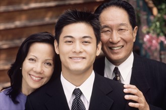 Portrait of a young man with his parents. Photographe : Rob Lewine
