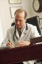 Doctor writing a prescription. Photographe : Rob Lewine