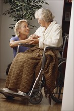 Attendant comforting an elderly woman in a wheelchair. Photographe : Rob Lewine